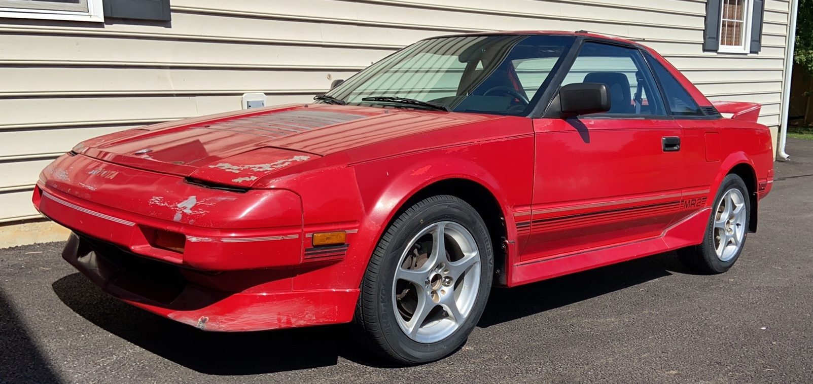 Red 1987 AW11 MR2 side view as purchased