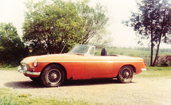 Photo of my first car a 1967 MGB roadster in orange with wire wheels